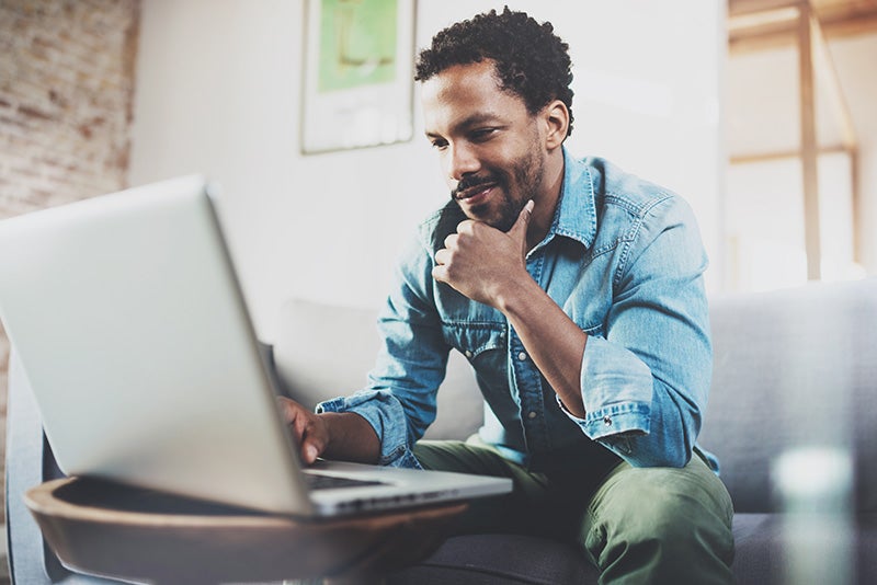 A man shopping for cars on his laptop